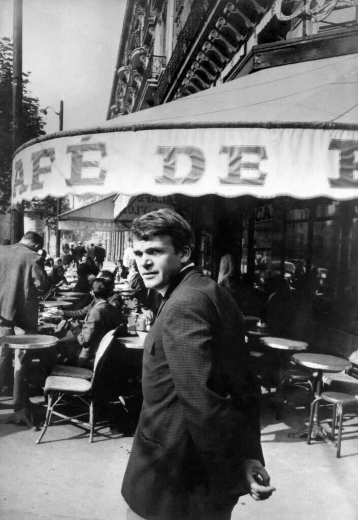 Milan Kundera passe devant un café du centre de Paris en 1975.