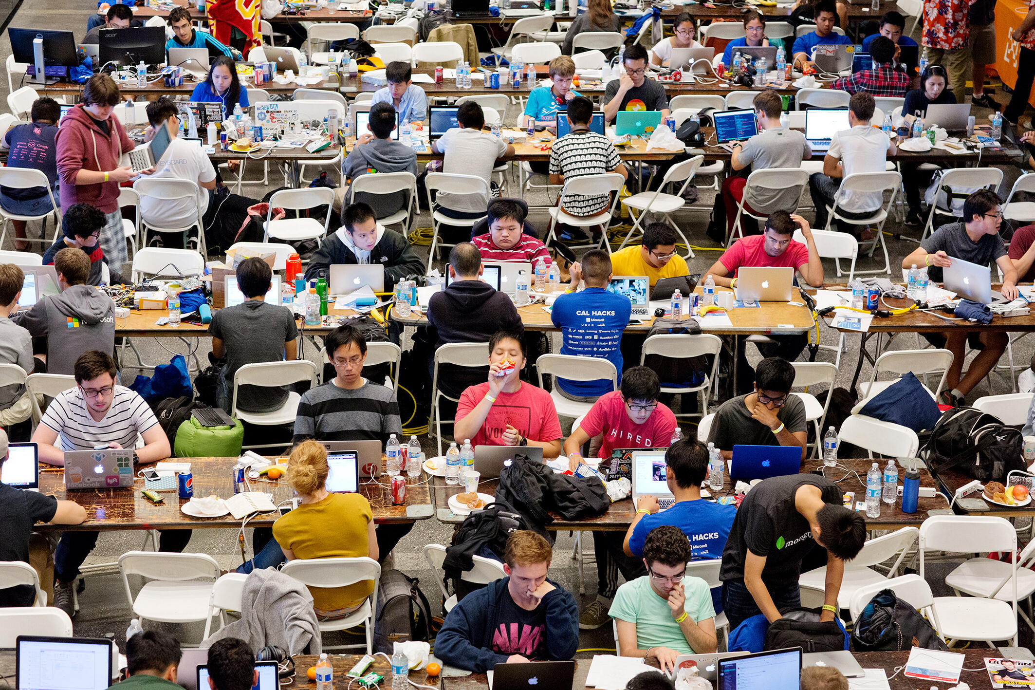Cal Hacks 2.0, un hackathon de 36 heures dans un stade de football, avec 2 071 participants venus de 143 écoles et dix pays.  Lors des hackathons, qui durent généralement quelques jours, les programmeurs et les développeurs de logiciels/matériels collaborent sur un projet, souvent en compétition pour des prix.  Les hackathons constituent une partie importante de l’écosystème de l’industrie technologique.  Université de Californie, Berkeley, Californie, octobre 2015.