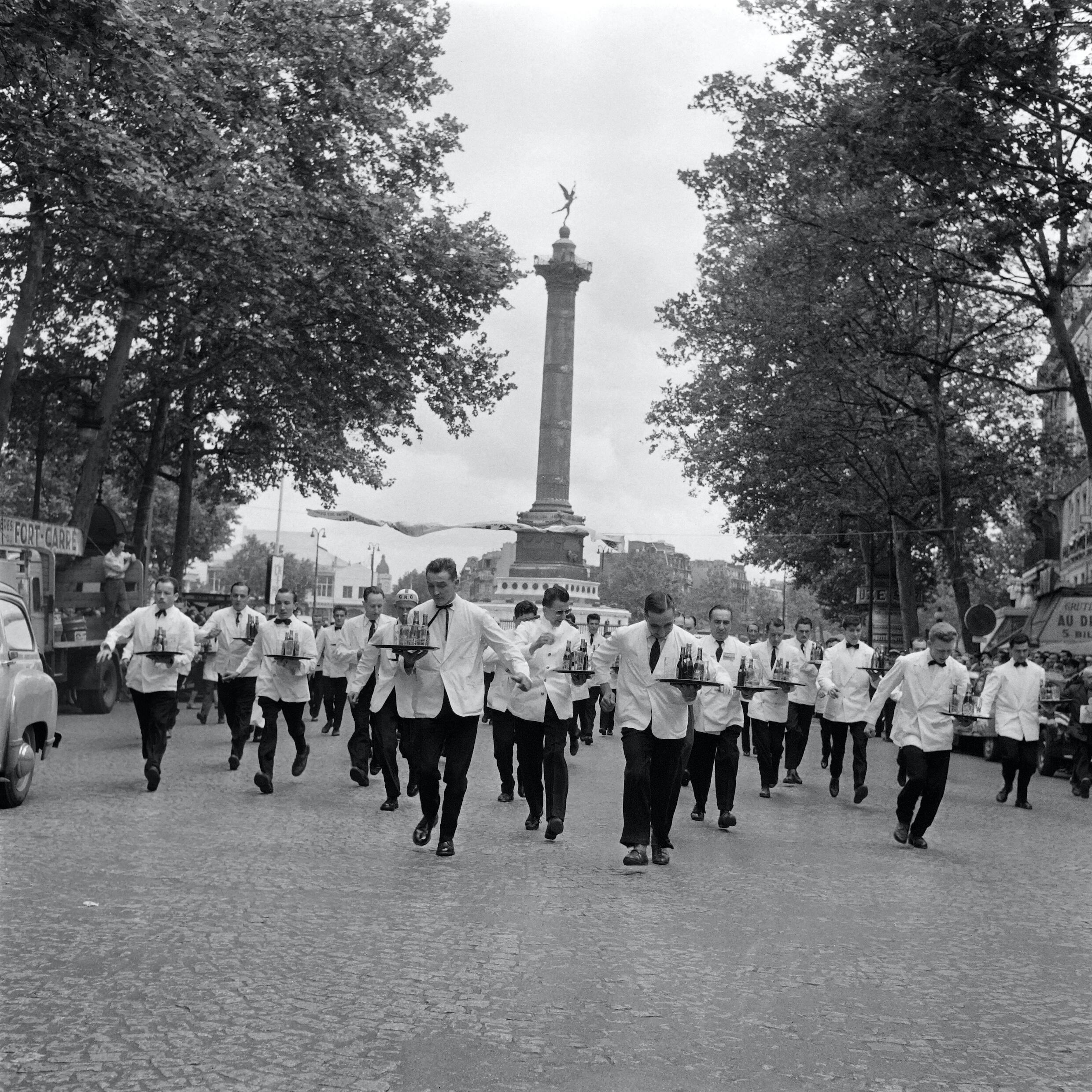 Des serveurs participent à une course le 8 juin 1957, place de la Bastille à Paris.