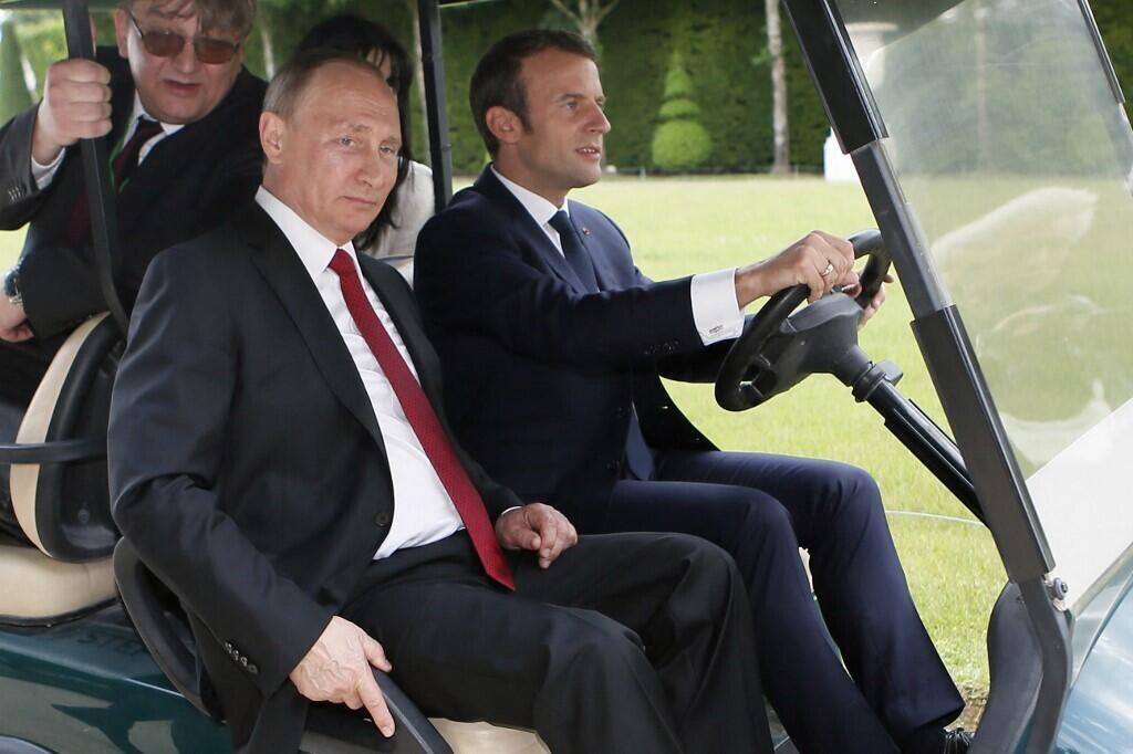 Le président français Emmanuel Macron aux commandes alors qu'il emmène son homologue russe Vladimir Poutine faire un tour dans les jardins du château de Versailles en mai 2017.