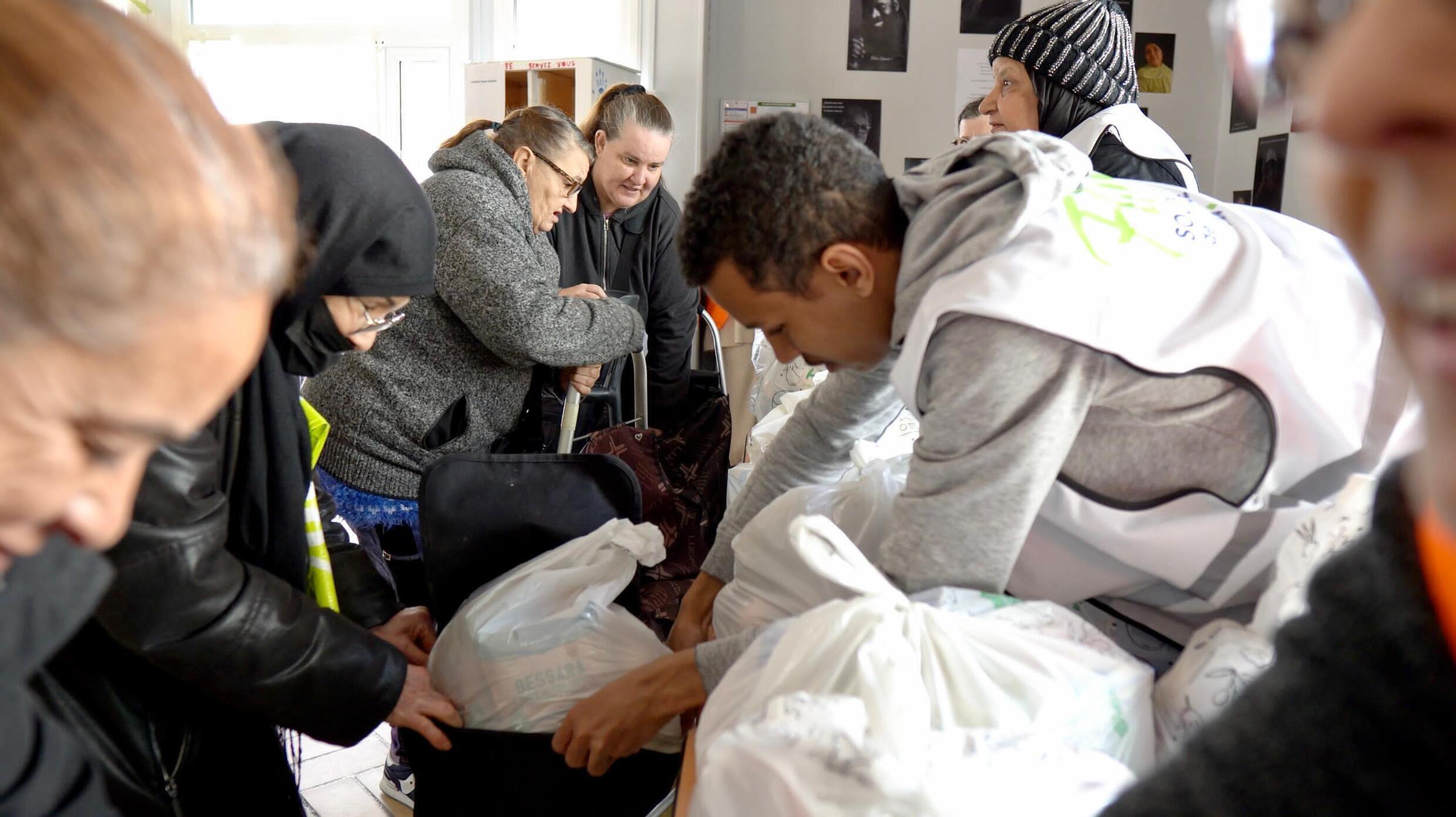 Un jeune volontaire de l'ONG LIFE prépare un sac de nourriture à Nanterre, banlieue populaire de Paris, lors de l'Iftar pour tous, le 28 mars 2024.