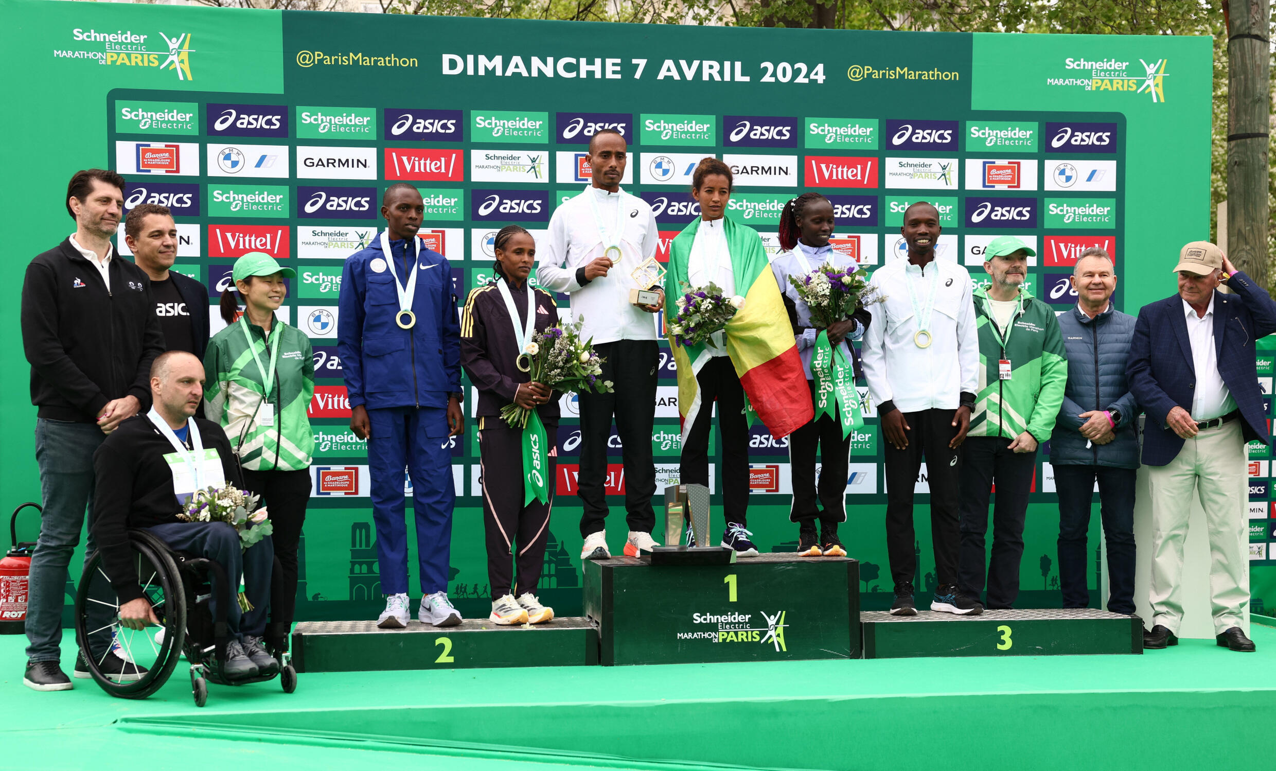 Les éthiopiens Mulugeta Asefa Uma et Mestawut Fikir (au centre) posent sur le podium aux côtés de Titus Kipruto du Kenya, deuxième, et d'Enat Tirusew, d'Éthiopie, et d'Elisha Rotich du Kenya, et Vivian Cheruiyot, du Kenya, troisièmes.  Le Français Julien Casoli, deuxième de la course élite masculine en fauteuil roulant, est également sur la photo.