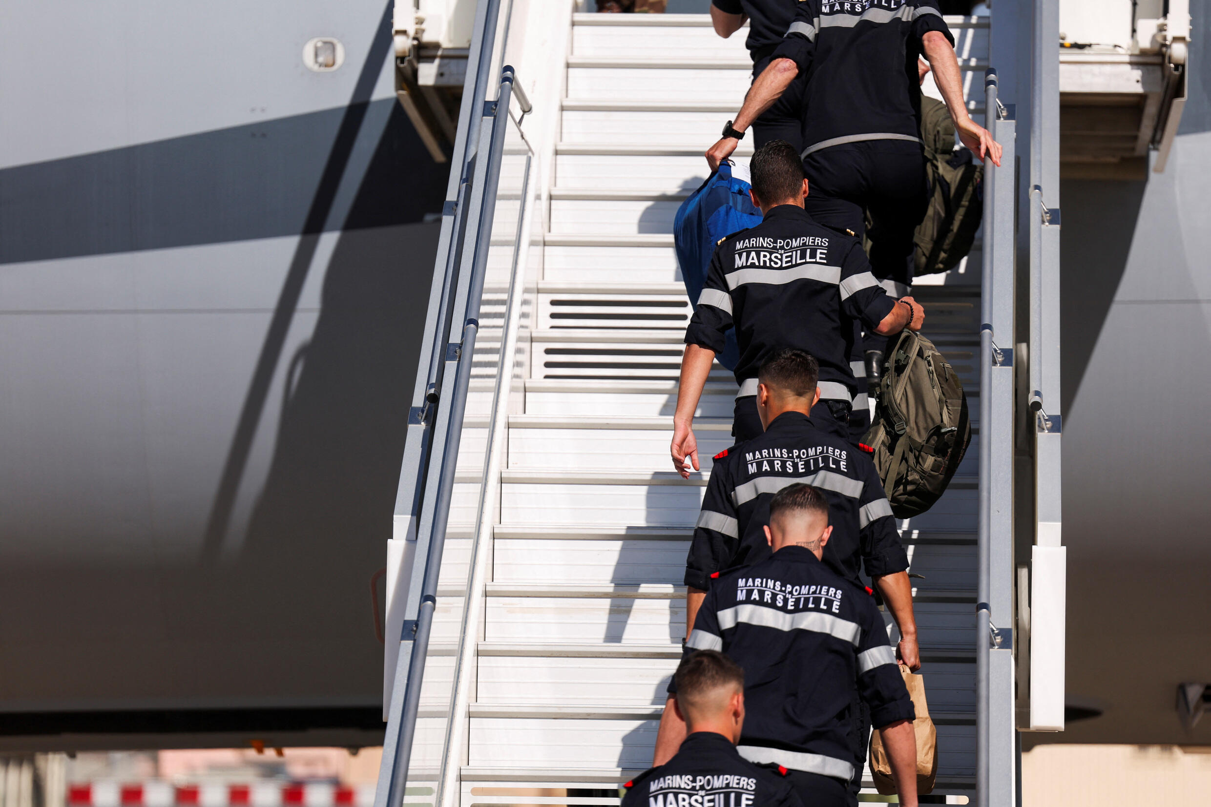 Des membres du bataillon des pompiers navals de Marseille montent à bord d'un avion de l'armée de l'air française sur la base aérienne militaire d'Istres après que la France a déclaré l'état d'urgence pour reprendre le contrôle des événements en Nouvelle-Calédonie, le 16 mai 2024.