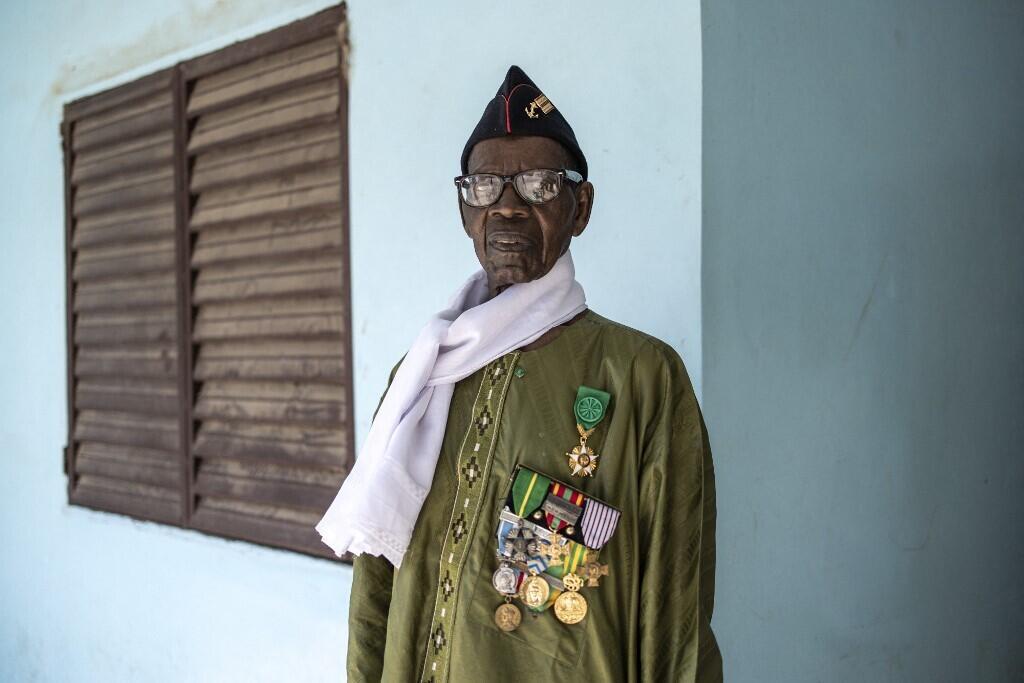 Oumar Dieme porte fièrement ses médailles sur son boubou traditionnel, sa casquette bleue est épinglée au grade de sergent.