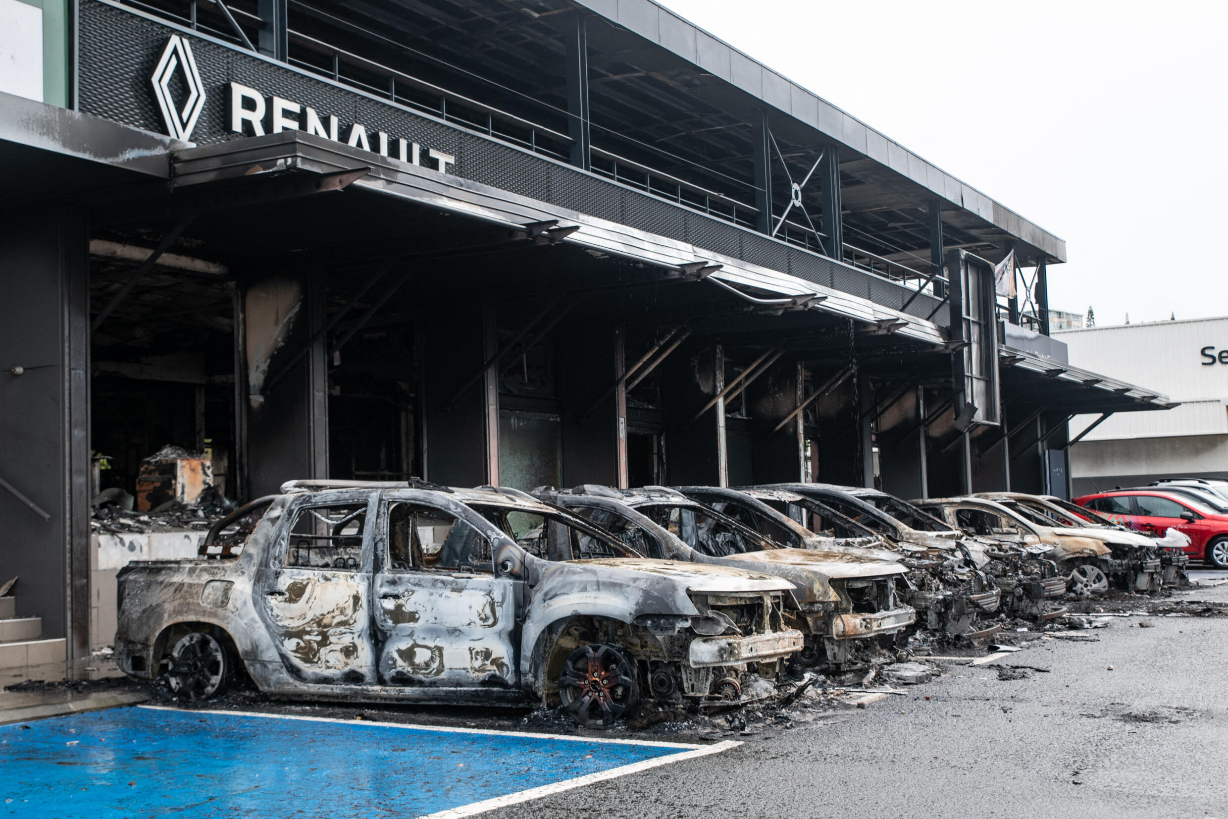 Cette photographie montre des voitures incendiées du parking Renault Dacia dans le quartier Magenta de Nouméa, territoire français du Pacifique de Nouvelle-Calédonie, le 17 mai 2024.