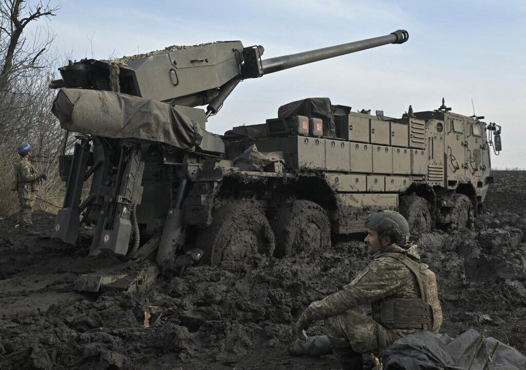 Un militaire ukrainien est assis à côté d’un obusier dans un lieu tenu secret du sud de l’Ukraine, le 14 février 2024, au milieu de l’invasion russe de l’Ukraine.