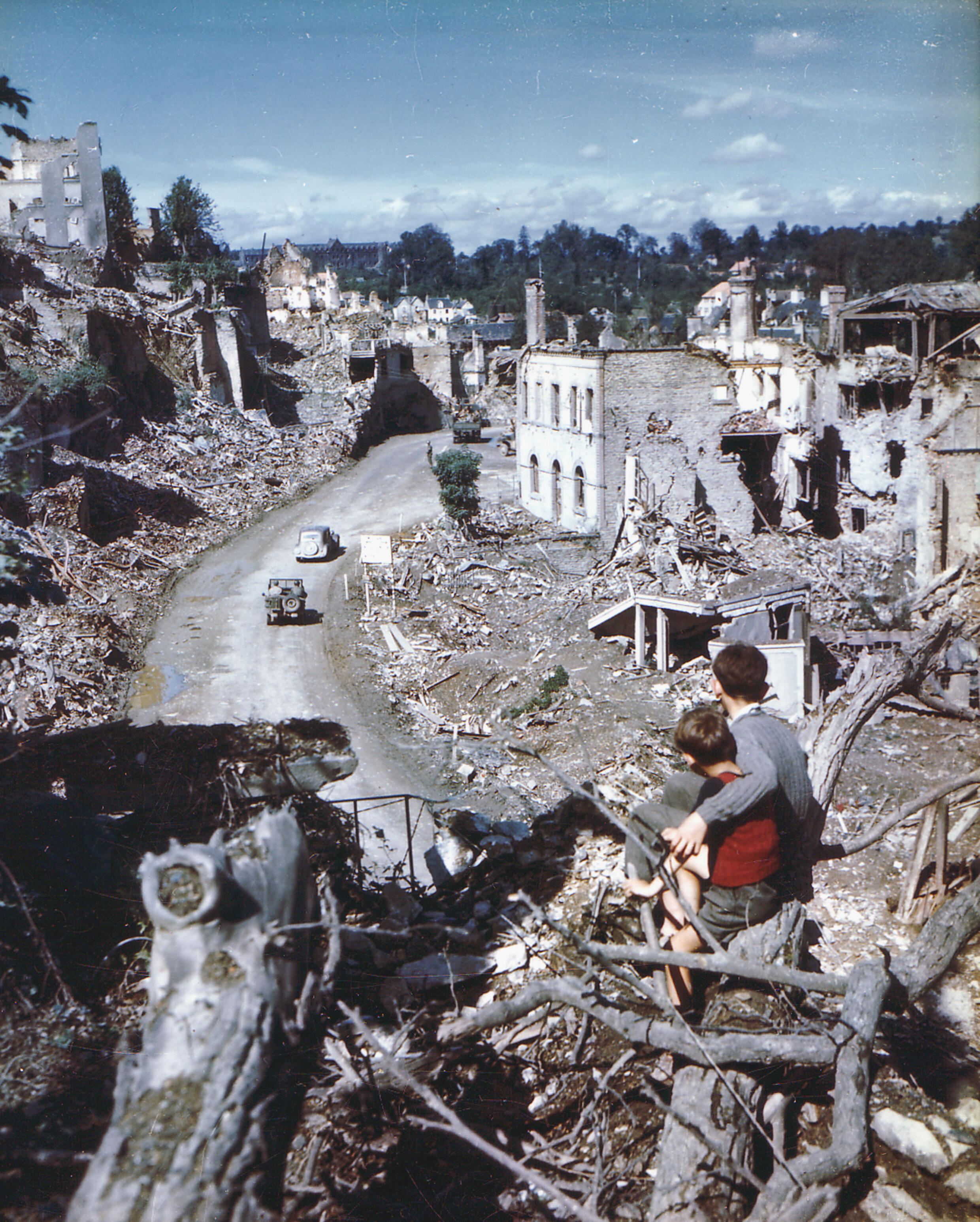 Deux enfants regardent une Jeep américaine traverser le centre en ruine de Saint-Lô en août 1944. Plus de 90 % de la ville a été détruite par les bombardements alliés cet été-là.