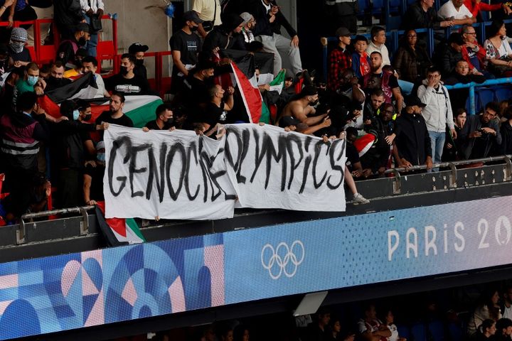 La banderole 'Genocide Olympics' dans une tribune lors du match Israël-Paraguay le 27 juillet 2024 au Parc des Princes. (GEOFFROY VAN DER HASSELT / AFP)