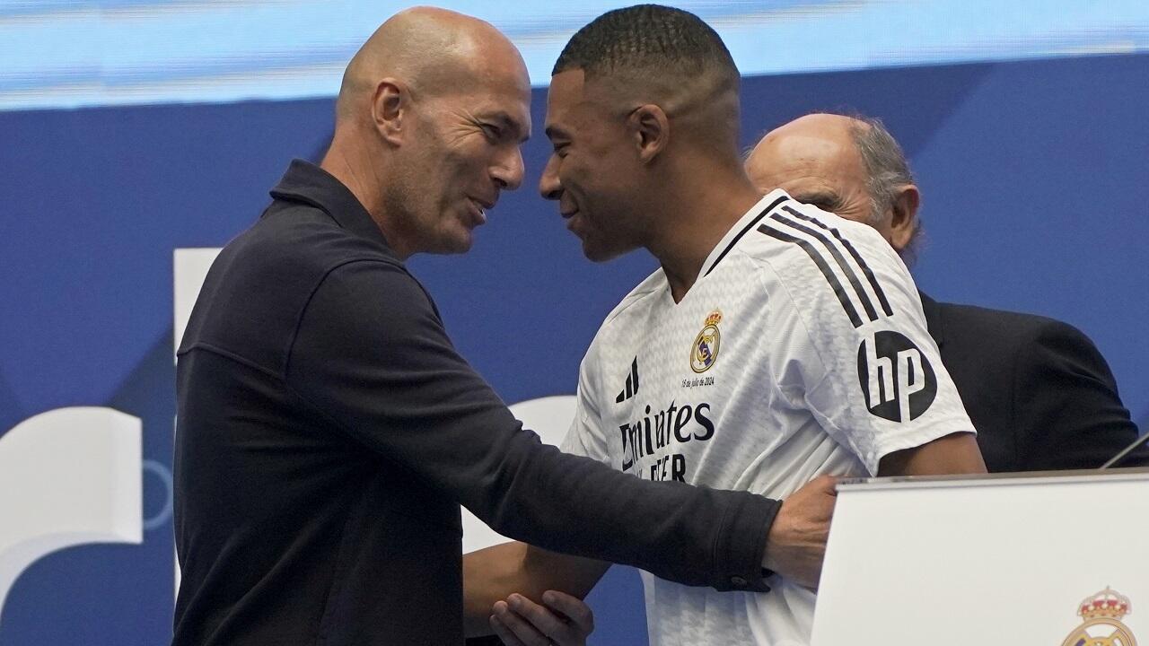 Kylian Mbappe, de France, embrasse l'ancien joueur français Zinedine Zidane, à gauche, tout en étant présenté aux fans comme nouveau joueur du Real Madrid au stade Santiago Bernabeu à Madrid, mardi 16 juillet 2024.