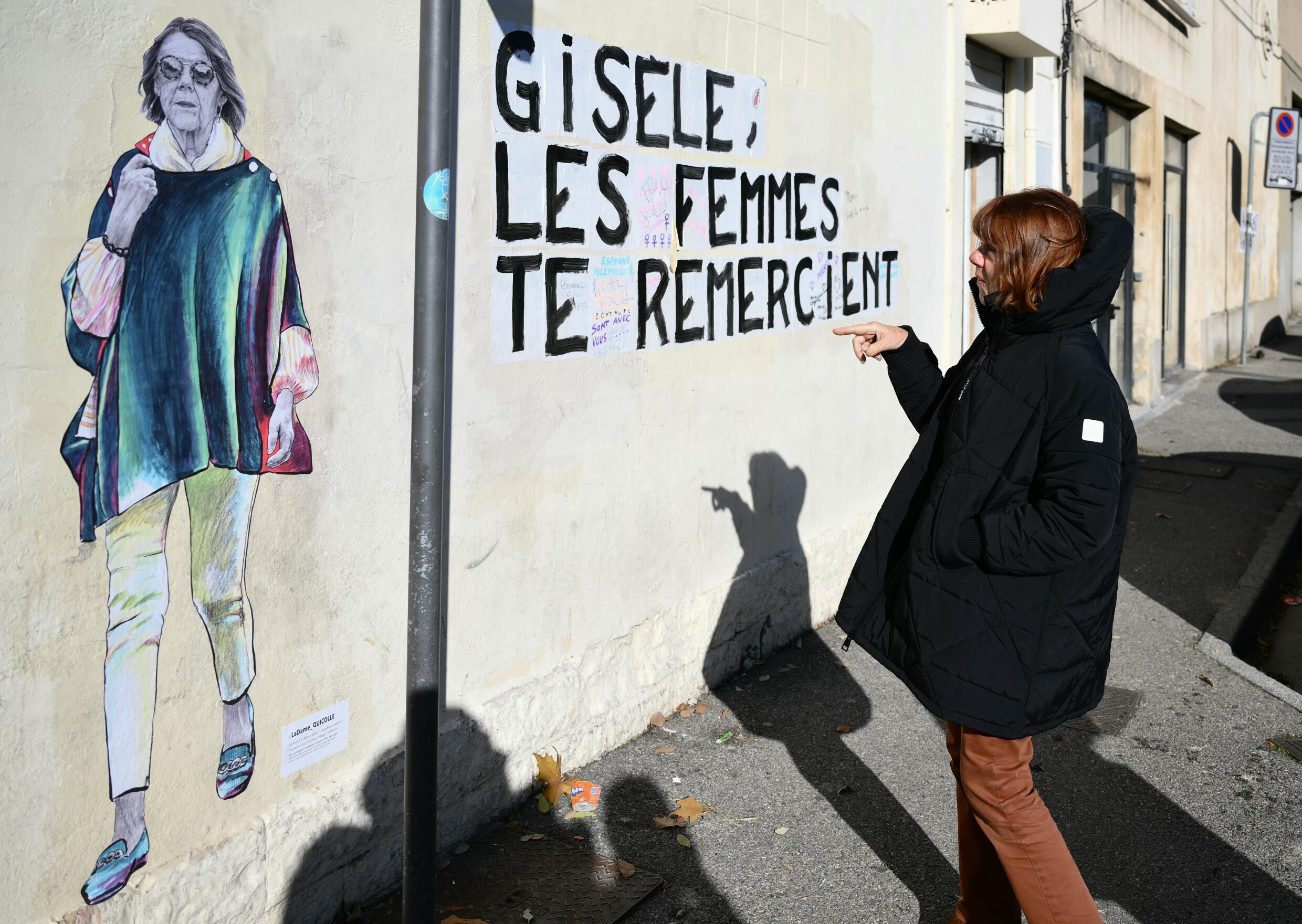 Pelicot à côté d'un portrait d'elle réalisé par un artiste de rue qui dit