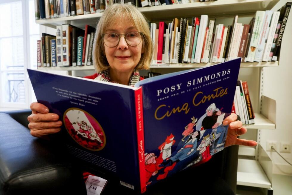 La caricature britannique Posy Simmonds pose avec son livre "Cinq Contes" (cinq contes) dans une bibliothèque lors du 52e Festival international de bandes dessinées d