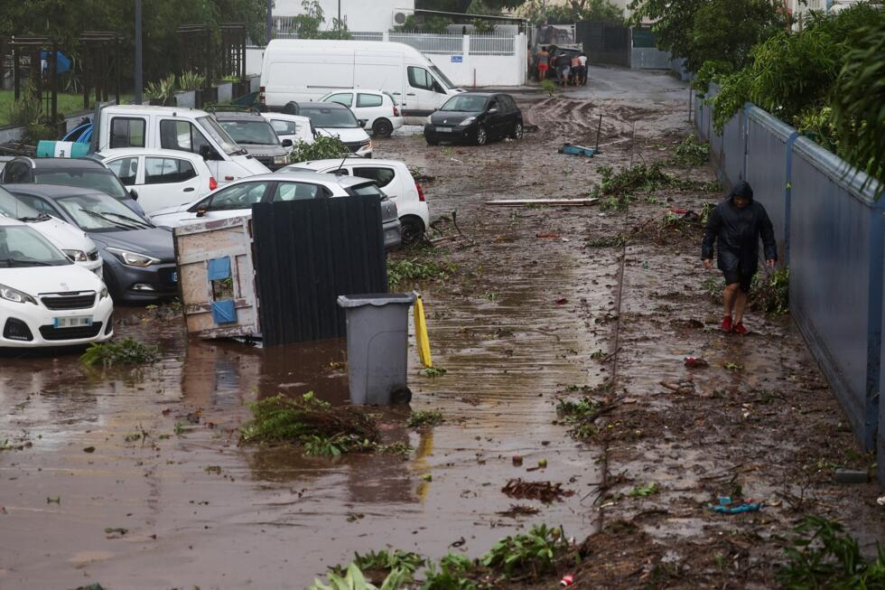 Un homme marche dans une rue endommagée à la suite du Garance du cyclone à Saint-Denis de la Réunion le 28 février 2025.