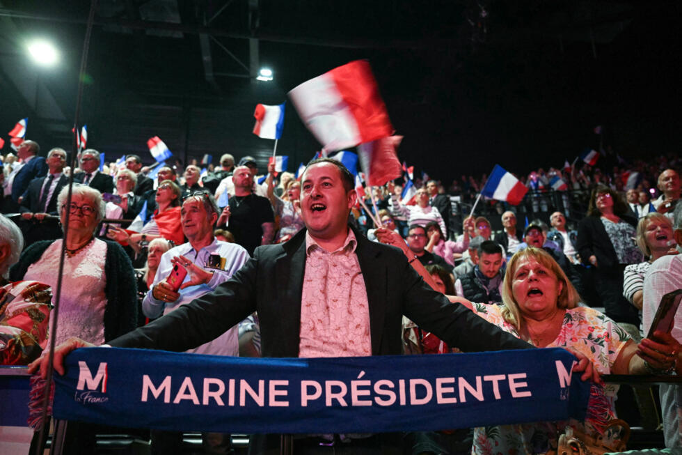Un partisan de la partie RN tient une lecture de bannière "Président marin" Lors de la réunion du jour du parti à Narbonne.