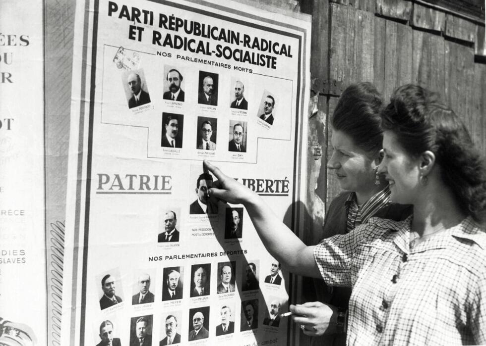 Les femmes françaises regardent un conseil électoral avant de voter pour la première fois lors des élections locales, à Paris, le 29 avril 1945.
