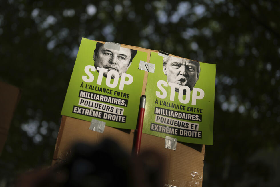 Les manifestants détiennent des affiches contre Elon Musk, à gauche, et le président Donald Trump lors de la manifestation du 1er mai, le 1er mai 2025 à Paris.