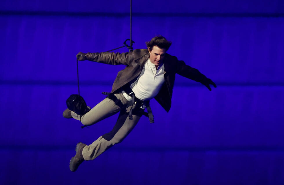 L'acteur Tom Cruise saute du toit du Stade de France à Paris lors de la cérémonie de clôture des Jeux Olympiques, le 11 août 2024.