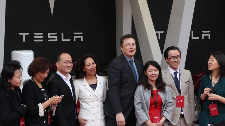 Le patron de Tesla, Elon Musk, pose avec les premiers acheteurs chinois, après l'ouverture du marché au constructeur américain, le 22 avril 2014, à Shanghaï. (SHANGHAI DAILY / IMAGINECHINA / AFP)